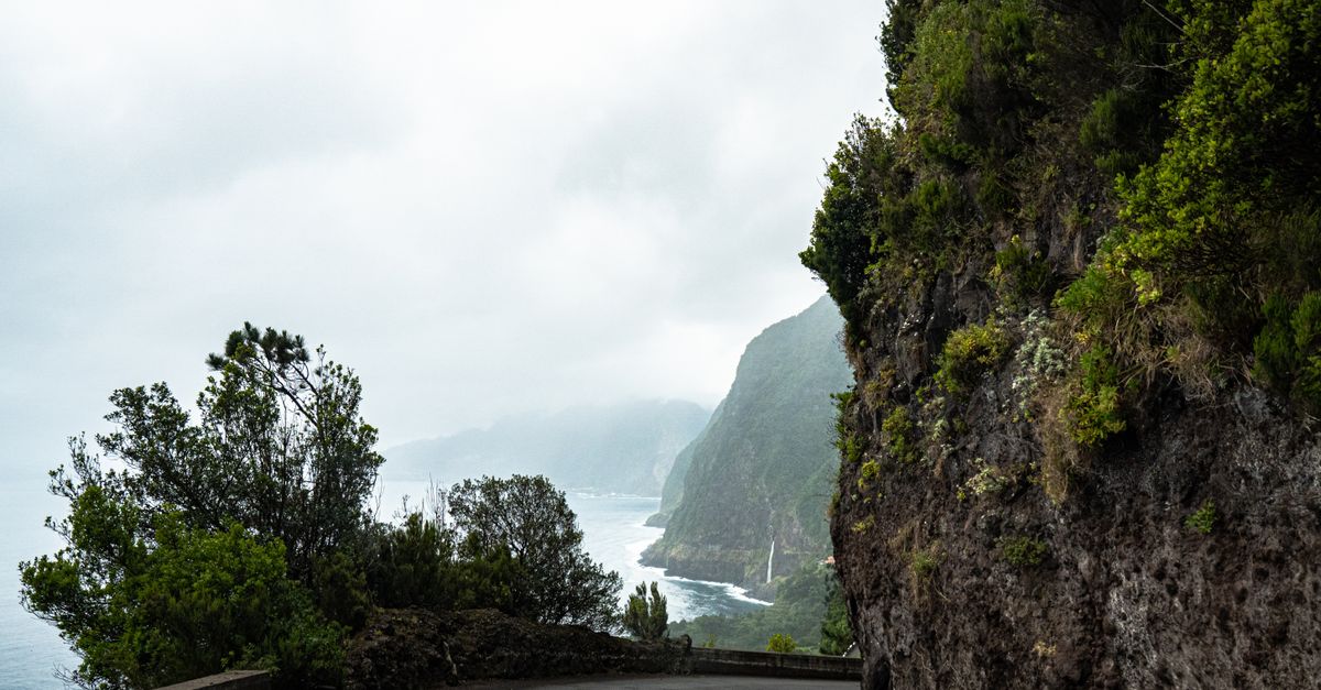 Narrow coastal road below steep cliffs in Madeira