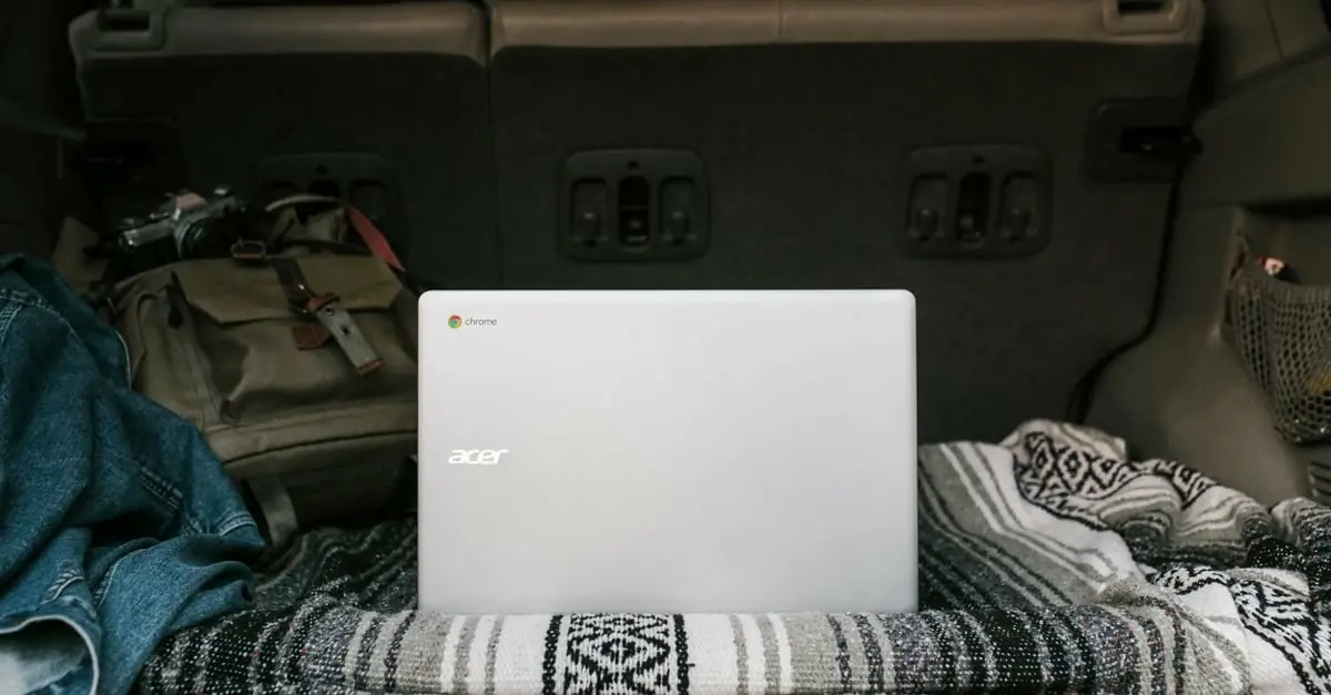 Laptop and travel belongings set up in the back of a vehicle