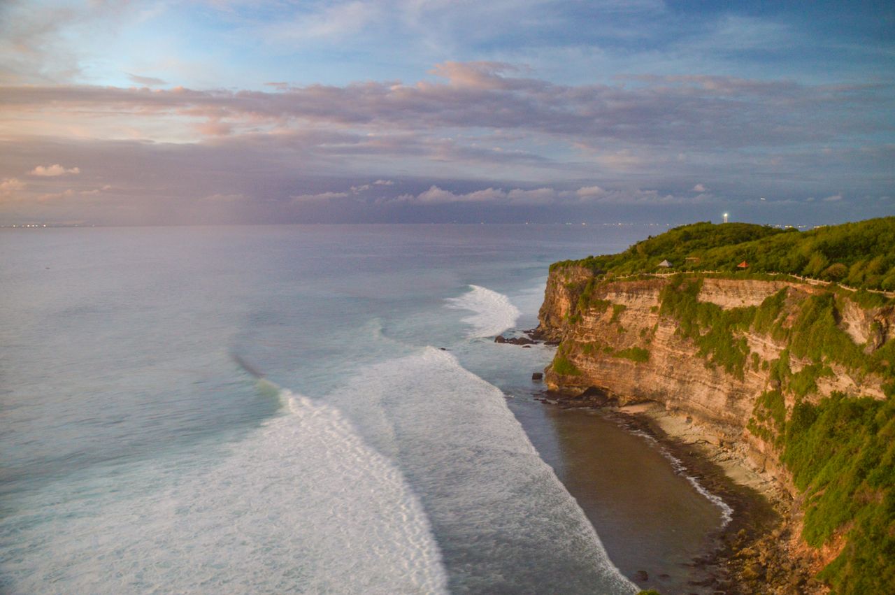 Waves breaking below high limestone cliffs on Bali’s south coast